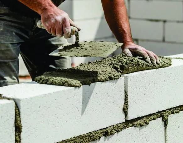 Mason laying AAC blocks with EMMA thin-bed mortar